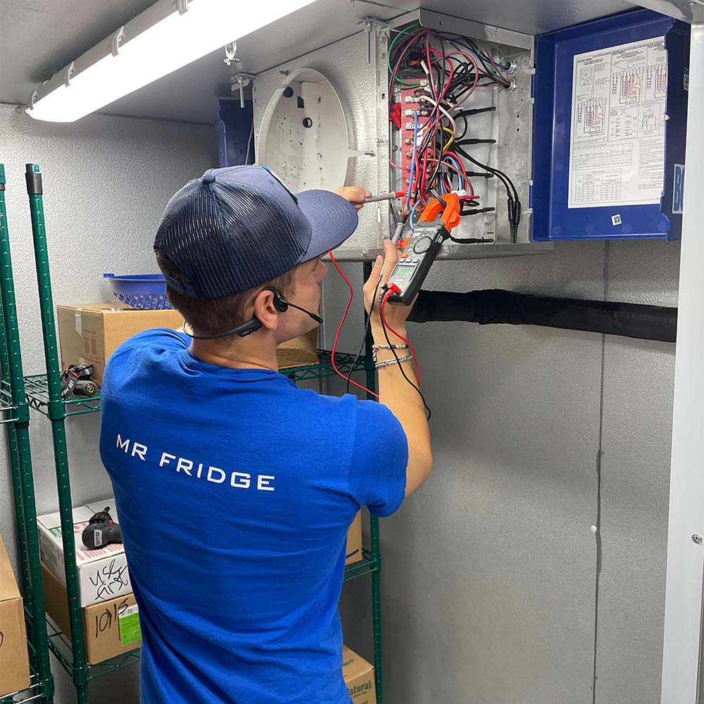 Mr. Fridge technician performing a walk-in cooler repair, providing professional and reliable service for commercial fridge repairs in Seattle, WA.