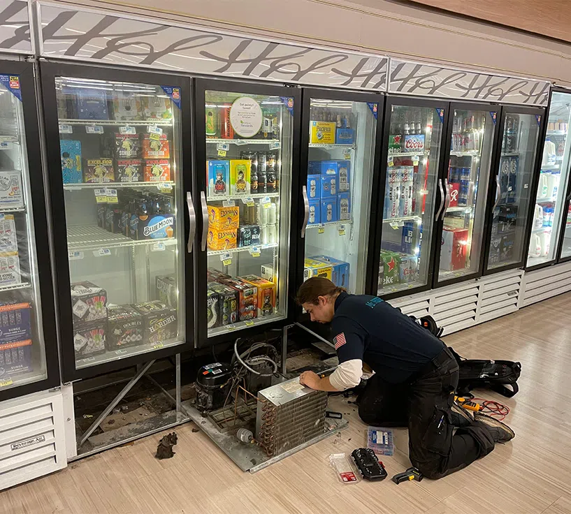 Mr. Fridge technician servicing a commercial walk-in fridge and display refrigeration unit.