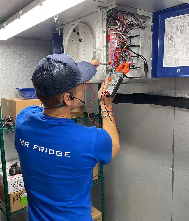 Commercial refrigeration repair technician in Seattle | Mr. Fridge Mr. Fridge technician repairing a commercial refrigeration unit control panel in Seattle